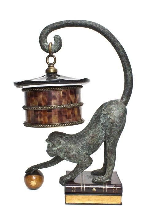 A Patinated Bronze and Faux Tortoise Shell Library: A Patinated Bronze and Faux Tortoise Shell Library Lamp, in the form of a monkey having an upturned tail holding a lantern, the front right paw resting on a ball, raised on two faux books. Height 22 1