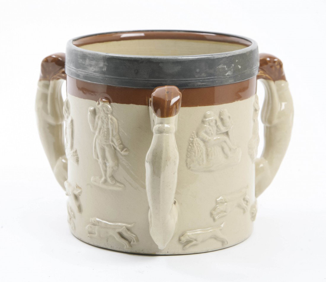 An English Stoneware and Silverplate Mounted Tyg,: An English Stoneware and Silverplate Mounted Tyg, having three hound form handles, the body decorated with molded topper and fox hunting scenes. Height 6 1/4 inches.