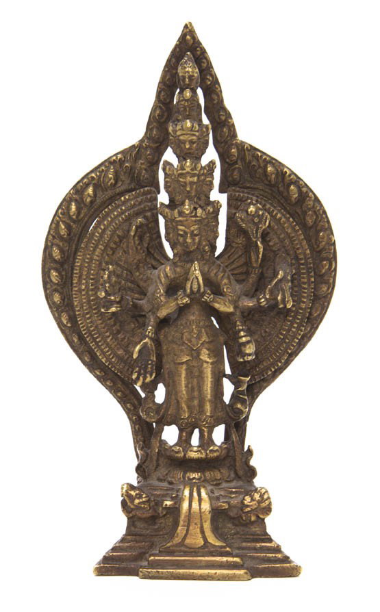 A Southeast Asian Bronze Figure of a Deity, Heigh: A Southeast Asian Bronze Figure of a Deity, the figure having eleven heads with elaborate headdresses and eight arms, two clasped and six holding various attributes, raised upon a double lotus base wi