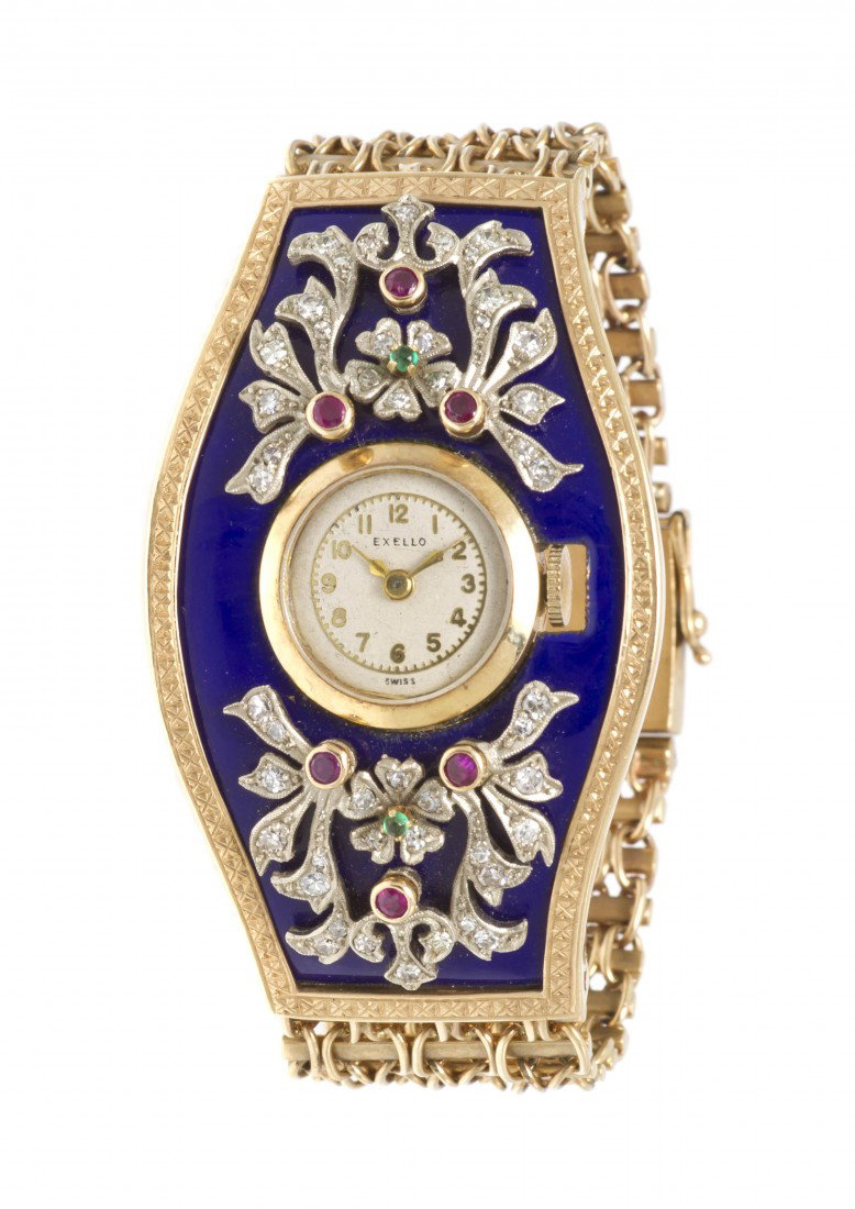 A 14 Karat Yellow Gold, Enamel, Ruby, Emerald, and: A 14 Karat Yellow Gold, Enamel, Ruby, Emerald, and Diamond Watch, Exello, containing numerous round single cut diamonds weighing approximately 0.50 carat total, tonneau case with blue enamel, emerald 