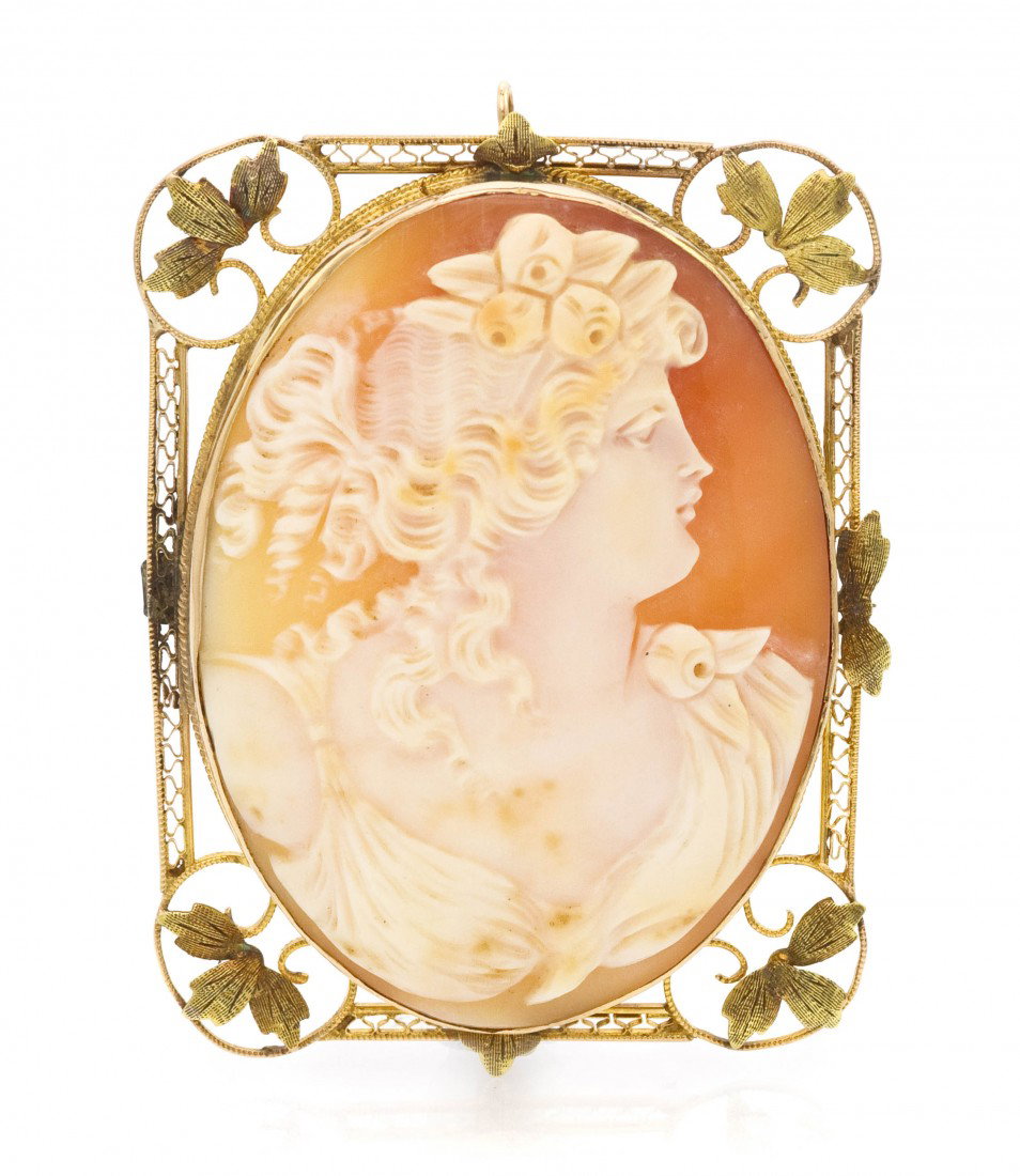 A 14 Karat Yellow Gold and Shell Cameo Pendant/Bro: A 14 Karat Yellow Gold and Shell Cameo Pendant/Brooch, consisting of an oval carved shell cameo depicting a Classical female profile with flower garland hair accent within a wirework and leaf accent s