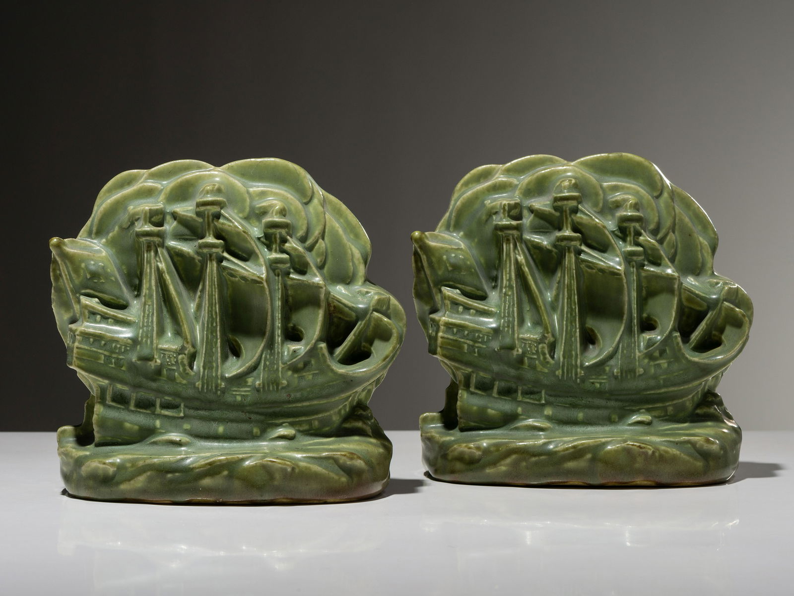 Rookwood Pottery American, Early 20th Century Pair of Galleon Bookends, 1926: Rookwood Pottery American, Early 20th Century Pair of Galleon Bookends, 1926 glazed earthenware impressed manufacturer's mark, date mark and number 2694 to underside H 5 x W 5 1/2 inches. This lot is