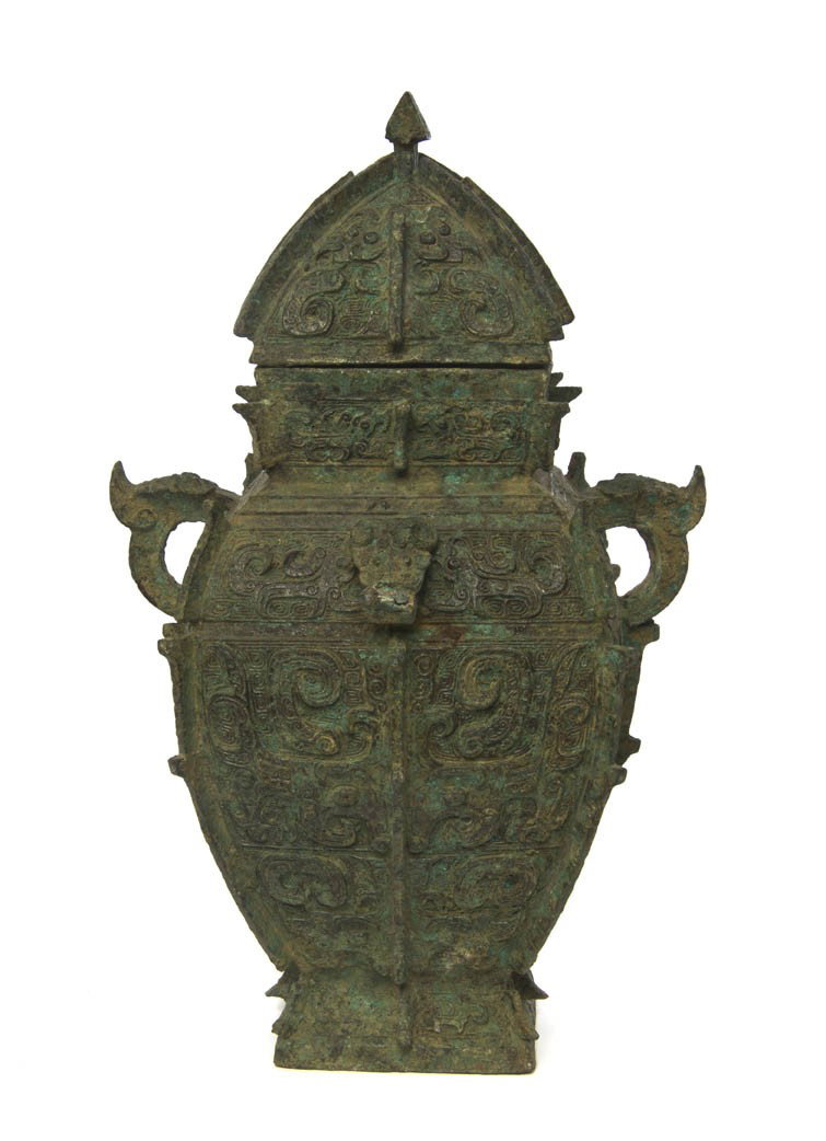 A Chinese Archaistic Style Bronze Vessel, Height 13: A Chinese Archaistic Style Bronze Vessel, the squared vase having conforming domed lid, the body flanked by animal form handles and flanked by animal head loop form handles at the front, the whole hav