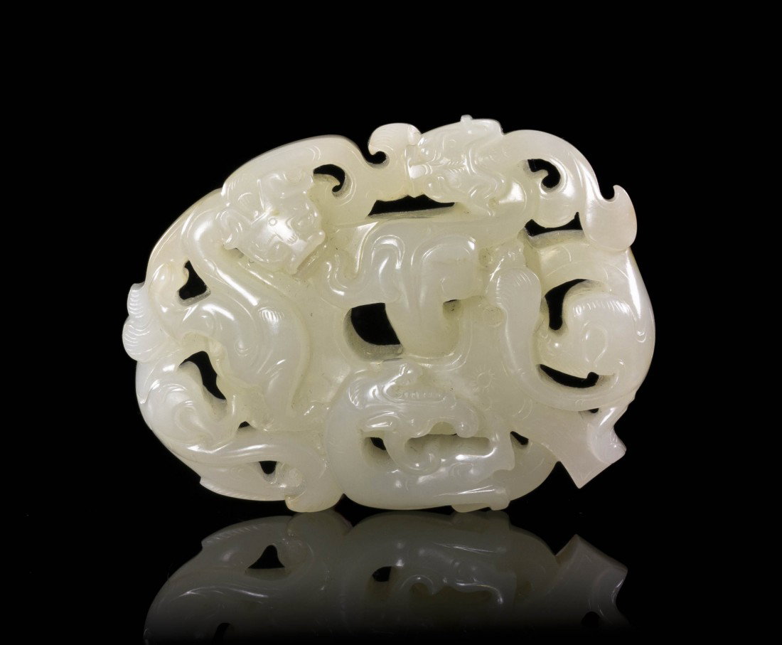 A Well Carved White Jade Bi, Width 2 3/4 inches.: A Well Carved White Jade Bi, of even semi-transparent stone, depicting the oval disk with three climbing qilong with bifurcated tails, the bi further decorated with incised decoration and having a sma