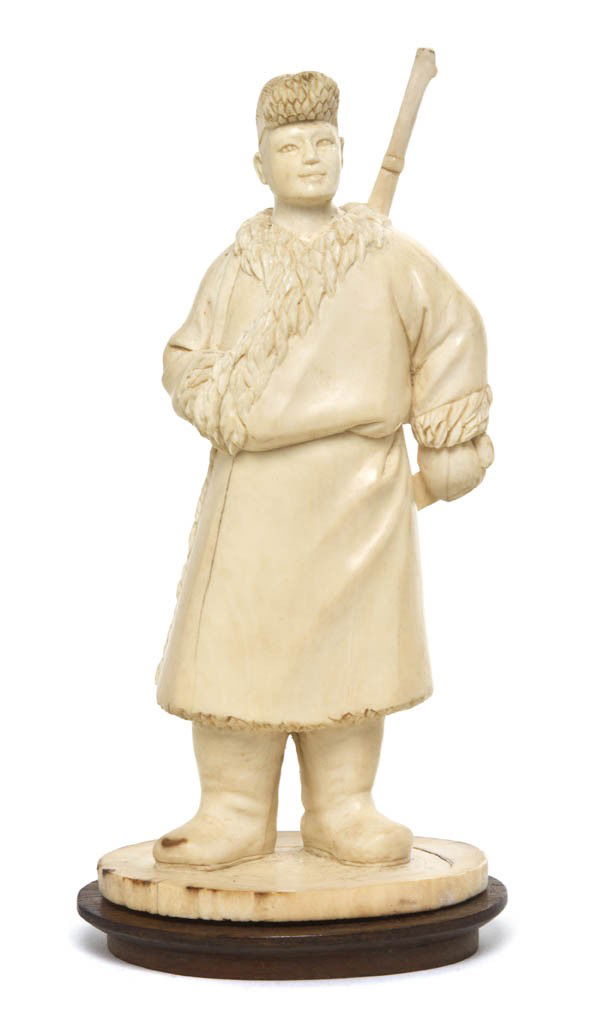 A Chinese Ivory Carving of a Soldier, Height 6 7/8: A Chinese Ivory Carving of a Soldier, Cultural Revolution period, depicting the soldier in a large fur-lined coat and gloves with large boots and having a rifle slung on his back. Height 6 7/8 inches.