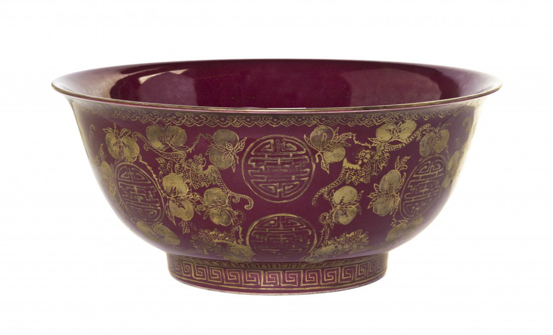 A Chinese Red-Glazed Center Bowl, Diameter 14 inch: A Chinese Red-Glazed Center Bowl, having gilt decoration of bats and peaches upon a red reserve, with a five-character mark on the bottom. Diameter 14 inches.