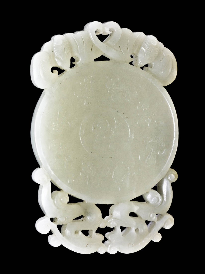 A Chinese Carved Jade Plaque, Width 3 1/4 inches.: A Chinese Carved Jade Plaque, of circular form, one side depicting eight Buddhist emblems centered with Fu, the character for prosperity, with carved double dragons at the top and double bats at the b