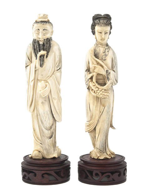 A Pair of Ivory Figures, Height of taller 8 1/8 in: A Pair of Ivory Figures, depicting a man holding his beard and a woman holding a basket, both raised atop pierced wood bases. Height of taller 8 1/8 inches.