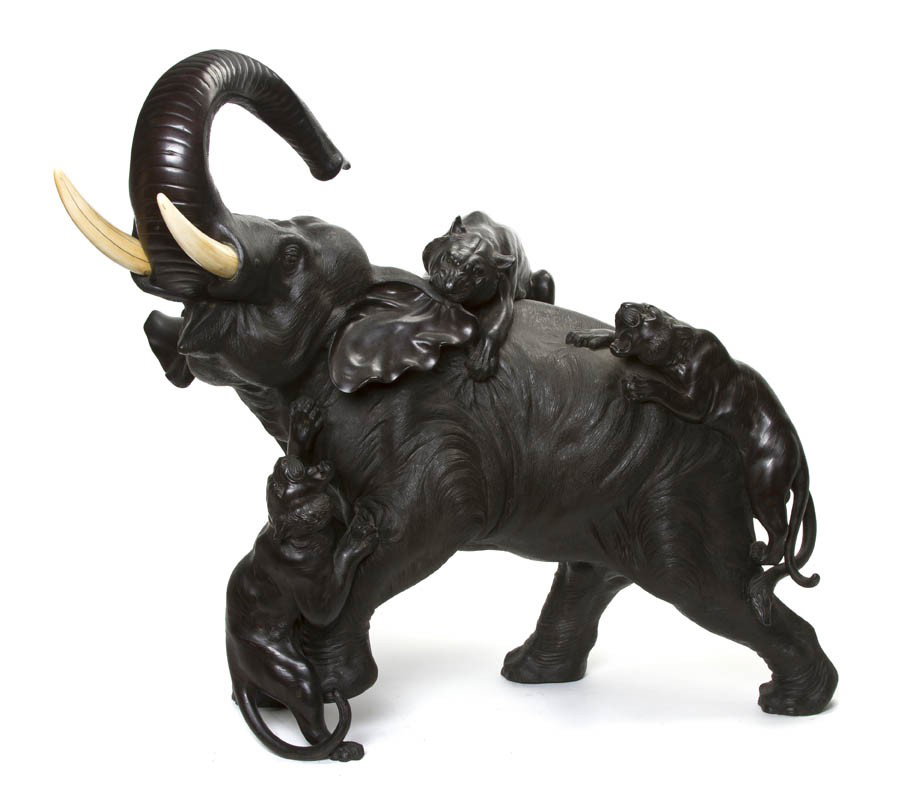 A Japanese Bronze Model of an Elephant, Width 30 i: A Japanese Bronze Model of an Elephant, Meiji period, depicting the elephant with ivory tusks being attacked by three tigers, signed. Width 30 inches. Condition: Item having light wear throughout with