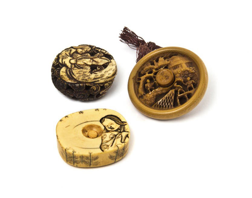 A Group of Three Manju Netsuke, Width of widest 2 : A Group of Three Manju Netsuke, one of a pierce carved stag antler depicting a figure holding a lotus blossom, one of ivory carved with a figure of a woman, and one of ivory pierce carved depicting fi