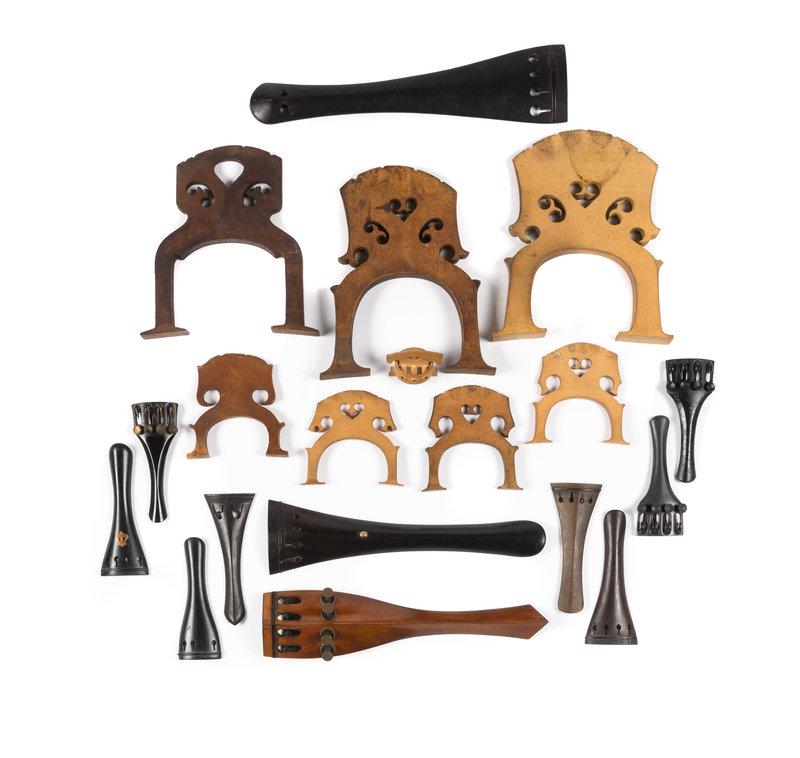 A Group of Stringed Instrument Parts Including Tailpieces and Bridges: A Group of Stringed Instrument Parts Including Tailpieces and Bridges 19th/20th Century comprising 113 various string instrument tailpieces made of wood, bone and resin, most with mother-of-pearl and 