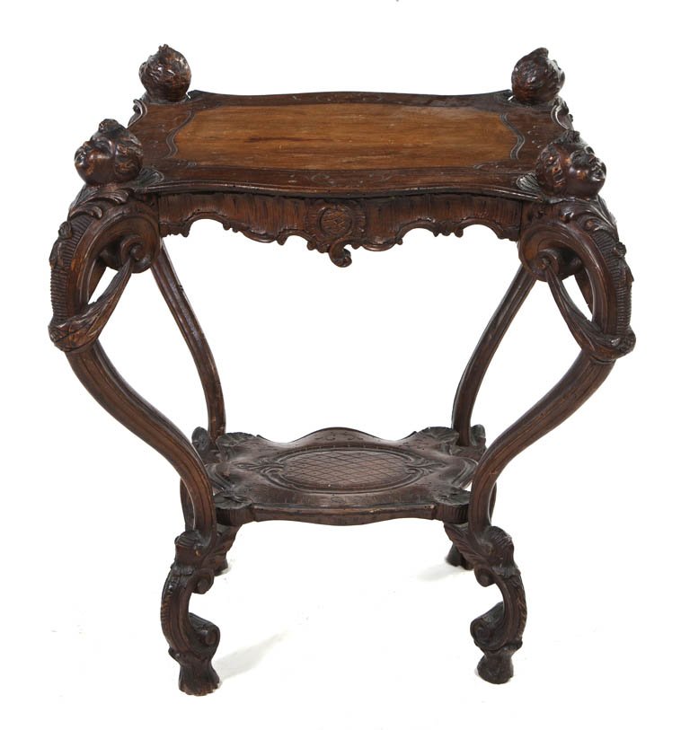 A Continental Carved Occasional Table, Height 28 1: A Continental Carved Occasional Table, of rectangular form with a medial shelf, raised on cabriole legs with putto masks at the knees. Height 28 1/2 x width 23 x depth 22 inches.