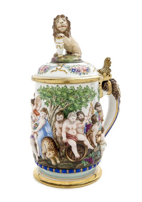 A Capodimonte Porcelain Stein, Height 9 3/4 inches: A Capodimonte Porcelain Stein, having a lion form finial and handle with a foliate thumbpress, the body modeled in high relief with a continuous scene of Bacchic revelry, with a crowned N mark in unde