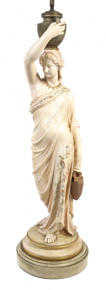 A Continental Ceramic Figure, Height of porcelain: A Continental Ceramic Figure, depicting a classically robed female carrying an amphora form vessel and balancing an urn on her head, mounted as a lamp. Height of porcelain 31 1/2 inches.