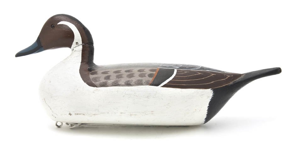 An American Carved and Polychrome Painted Duck Dec: An American Carved and Polychrome Painted Duck Decoy, Charles Perdew, Henry, Illinois, depicting a Pintail drake with glass eyes, having typical Perdew lead strip weight on the bottom reading Henry ..