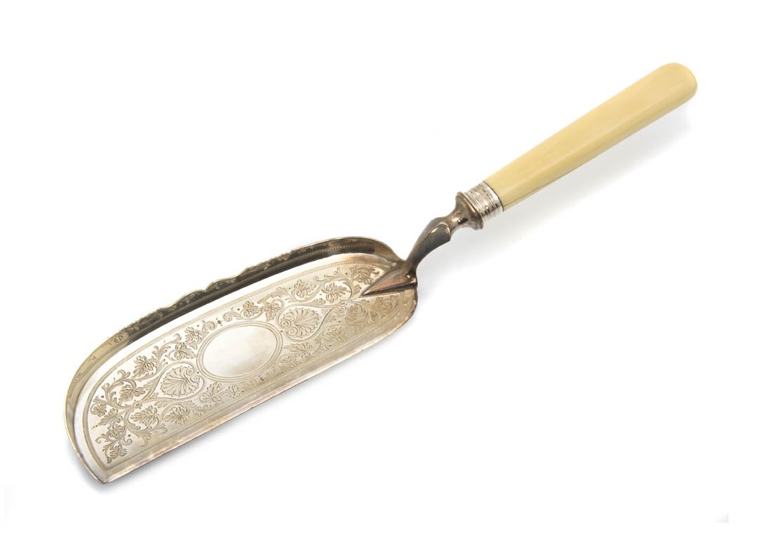 An English Silver Crumber, Martin, Hall & Co., Le: An English Silver Crumber, Martin, Hall & Co., Sheffield, 1863, with engraved Adam style decoration and ivory handle, contained in a fitted case. Length 12 7/8 inches.