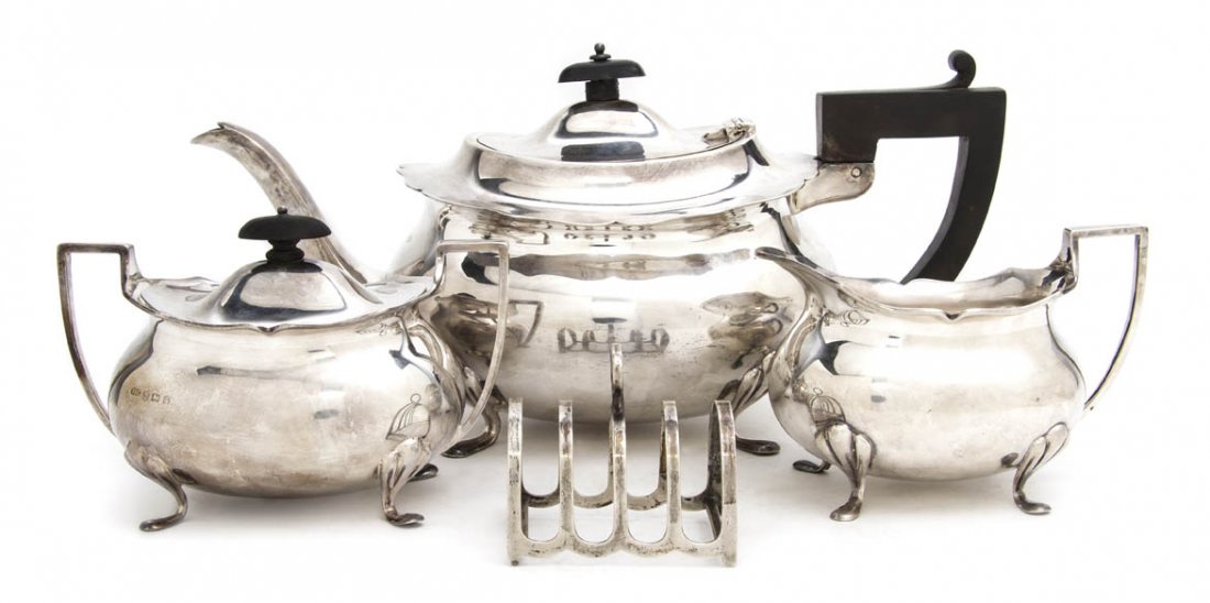 An English Silver Teapot, C.T. Burrows & Son, Hei: An English Silver Teapot, C.T. Burrows & Son, Birmingham, 1912, having an ebonized wood handle and finial, together with a creamer and covered sugar hallmarked SC, 1930, and a toast rack by Barker Bro