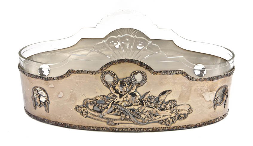 A Silverplate and Glass Lined Jardiniere, Width 1: A Silverplate and Glass Lined Jardiniere, the oval bowl cast in relief with musical putti, raised on six squared columnar supports over the rose cast stepped base. Width 17 1/4 inches. Property from t