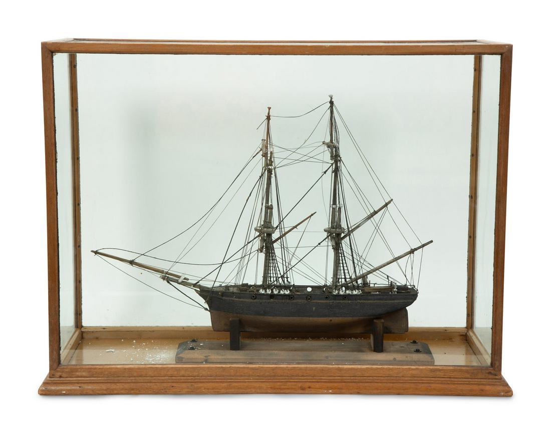 Two Ship Models in Glass Display Cases: Two Ship Models in Glass Display Cases Early 20th Century comprising a two-masted clipper ship and an English three-masted ship with cloth sails, miniature supplies and crew.Height of cases 16 x width