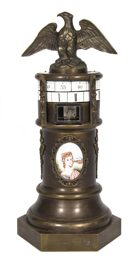 A Continental Cast Metal and Porcelain Inset Annu: A Continental Cast Metal and Porcelain Inset Annular Clock, having a spread wing eagle over the enameled dials with Arabic minutes and Roman hours, set in a cylindrical case decorated with two porcela