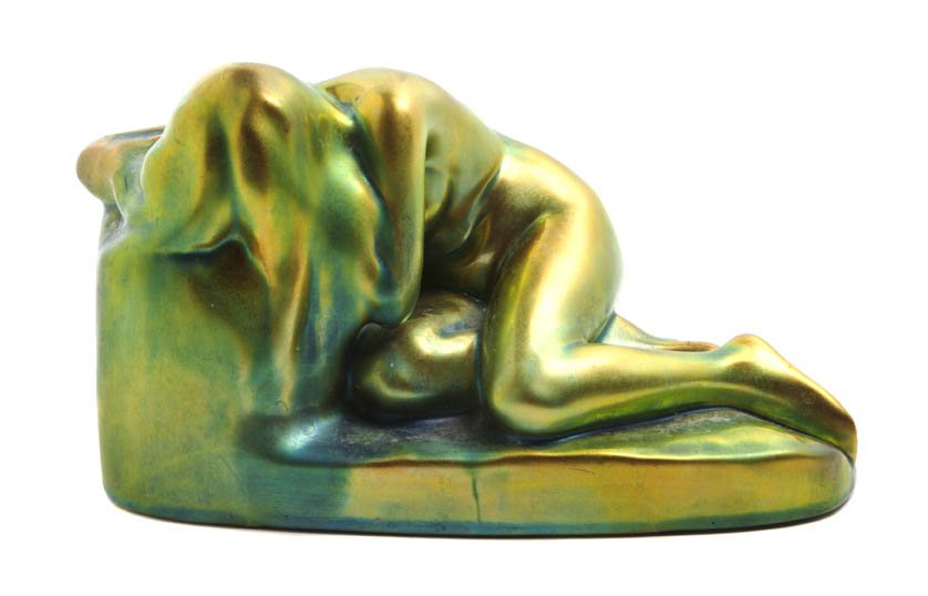 A Zsolnay Porcelain Figure, Width 9 1/4 inches.: A Zsolnay Porcelain Figure, depicting a nude maiden weeping, with green iridescence. Width 9 1/4 inches.