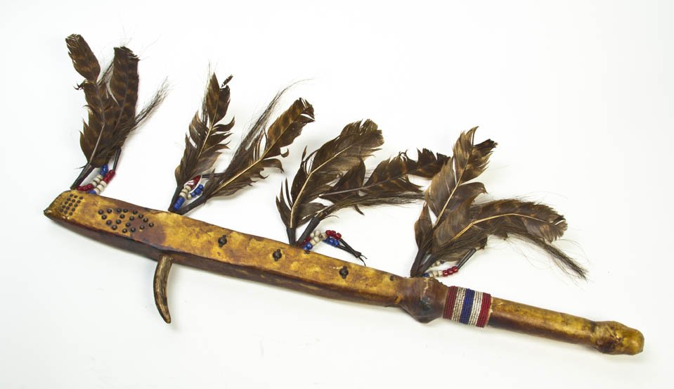 A Leather Clad Native American Tomahawk, Length 2: A Leather Clad Native American Tomahawk, mounted with beads and turkey feathers. Length 29 inches.