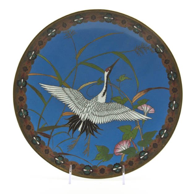 A Japanese Cloisonne Enamel Charger, Diameter 11: A Japanese Cloisonne Enamel Charger, of circular, footed form, decorated with a crane and flowering foliage on a blue ground, with a repeating medallion and cartouche pattern border, the reverse depic