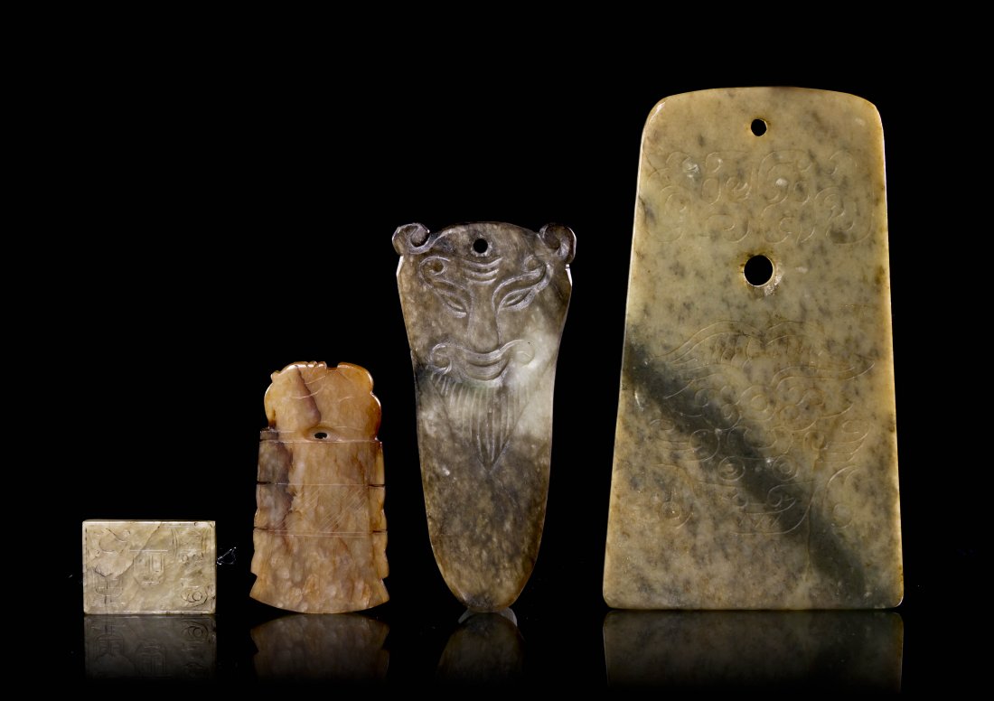 A Group of Four Archaistic Jades, Height of talle: A Group of Four Archaistic Jades, comprising one large blade with incised decoration, a dagger form carving with a mask at top, a ritualistic blade and a rectangular toggle. Height of tallest 6 inches