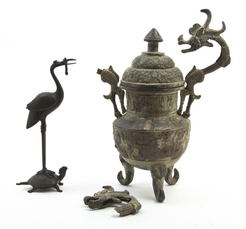 A Chinese Archaistic Style Wine Vessel, Height of: A Chinese Archaistic Style Wine Vessel, having dragon form handles and taotie decoration in relief, raised on three scrolled feet, together with a bronze crane depicted standing on a turtle. Height of