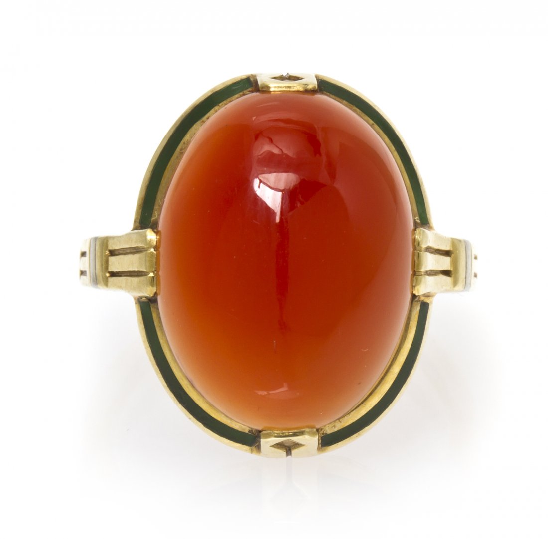 A Vintage 14 Karat Yellow Gold, Carnelian and Ename: A Vintage 14 Karat Yellow Gold, Carnelian and Enamel Ring, containing one oval cabochon cut carnelian weighing approximately 8.00 carats within a textured gold setting with green enamel accents. Stamp