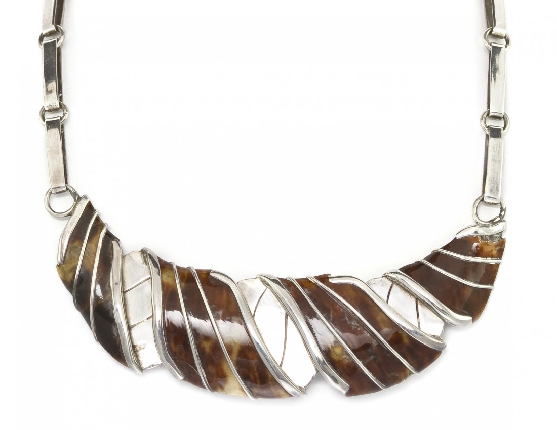 A Sterling Silver and Tortoiseshell Necklace, Will: A Sterling Silver and Tortoiseshell Necklace, William Spratling, consisting of a central spiral motif component containing four carved tortoiseshell sections suspended from a bar link chain. Stamp: (m