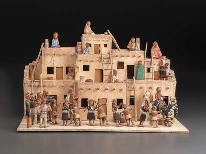 A Native American Village Mixed Media Diorama: A Native American Village Mixed Media Diorama 20th Century depicting a pastiche of Hopi and Navajo figures, some in a community dance outside of a pueblo. housed in a plexiglass case. Height 21 1/2 x
