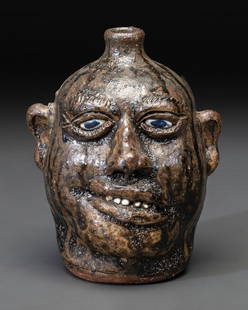 A Southern Stoneware Face Jug: A Southern Stoneware Face Jug by Lanier Meaders (Mossy Creek, Georgia, 1917-1998), signed Lanier Meaders, on underside. Height 9 1/8 inches. This lot is located in Cincinnati.