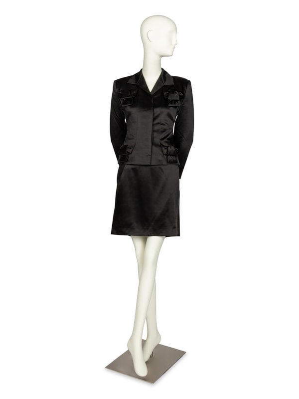 Givenchy Couture Skirt Suit by John Galliano, 1996: Givenchy Couture Skirt Suit by John Galliano, 1996 THE FIRSTSingle-breasted button-front jacket in black wool/rayon blend. Features four decorative bow embellishments, a hidden placket, and a ful