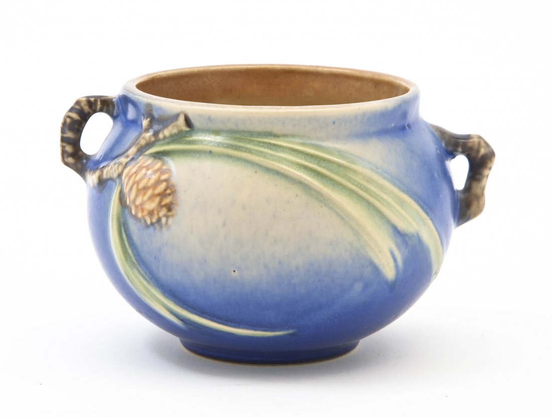 A Roseville Pottery Vase, Width over handles 5 in: A Roseville Pottery Vase, modeled with pine cones and twig form handles on a blue ground. Width over handles 5 inches. Property from the Collection of Nancy B. and Peter G. Kohler, Kohler, Wisconsin