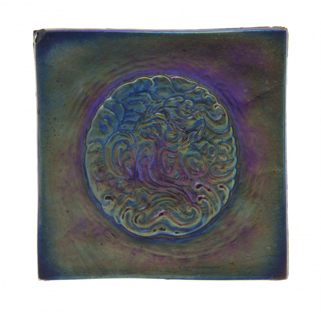 An American Favrile Glass Tile, attributed to Tif: An American Favrile Glass Tile, attributed to Tiffany Studios, of square form with a round central medallion, marked Appl'd for to verso. Height 3 7/8 inches.