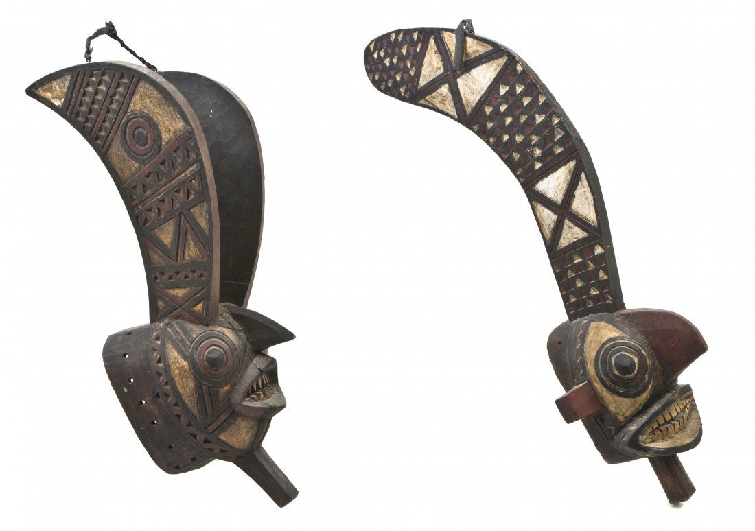 Two African Gurunsi Style Carved Masks, Height of: Two African Gurunsi Style Carved Masks, each with bared teeth and geometric polychrome decoration throughout. Height of tallest 34 5/8 inches. Property from the Estate of Edward F. Donohue, Grosse Poi