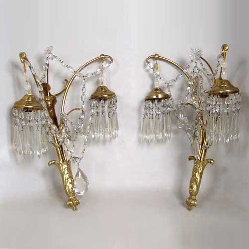 A Pair of French Wall Sconces, Height 19 x width 1: A Pair of French Wall Sconces, circa 1920, the wall plate with leaf base issuing two downward-turned arms with pendant lights; cut glass swags, rosettes and prisms throughout. Height 19 x width 13 x d