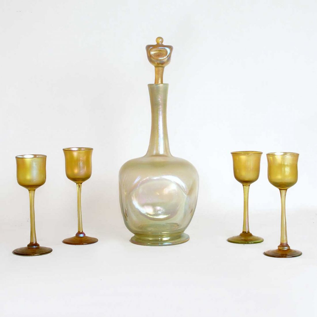 An American Tiffany Studios Favrile Glass Decanter: An American Tiffany Studios Favrile Glass Decanter & Four Stemmed Cordials, circa 1900, comprising four cordials and a hand blown, pale gold opalescent decanter fitted with a stopper top; with etched 