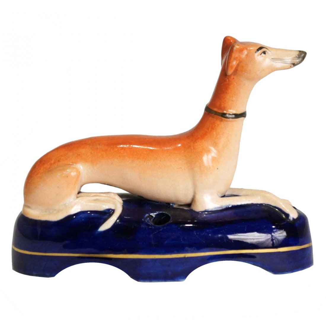 An English Victorian Staffordshire Pottery Whippet: An English Victorian Staffordshire Pottery Whippet Dog Inkwell, circa 1860, the recumbent russet colored Staffordshire whippet with gold collar, seated alertly with paws crossed, resting on a dark blu