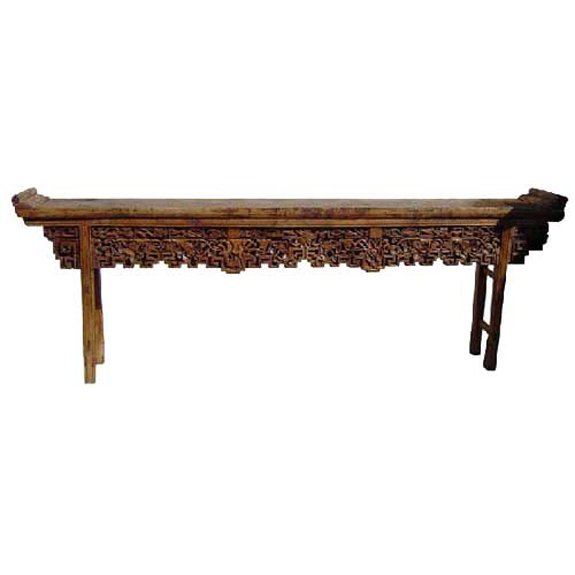 A Chinese Shanxi Poplar Trestle-Leg Altar Table, H: A Chinese Shanxi Poplar Trestle-Leg Altar Table, circa 1840, having a single plank top with everted flanges, featuring an apron with carved flora and a geometric key edge. Height 36 x width 102 x dept