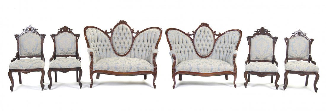 A Victorian Parlor Suite, Width 54 inches.: A Victorian Parlor Suite, comprising two settees and four chairs, each having a carved crest rail over the upholstered back and seat, raised on cabriole legs. Width 54 inches.
