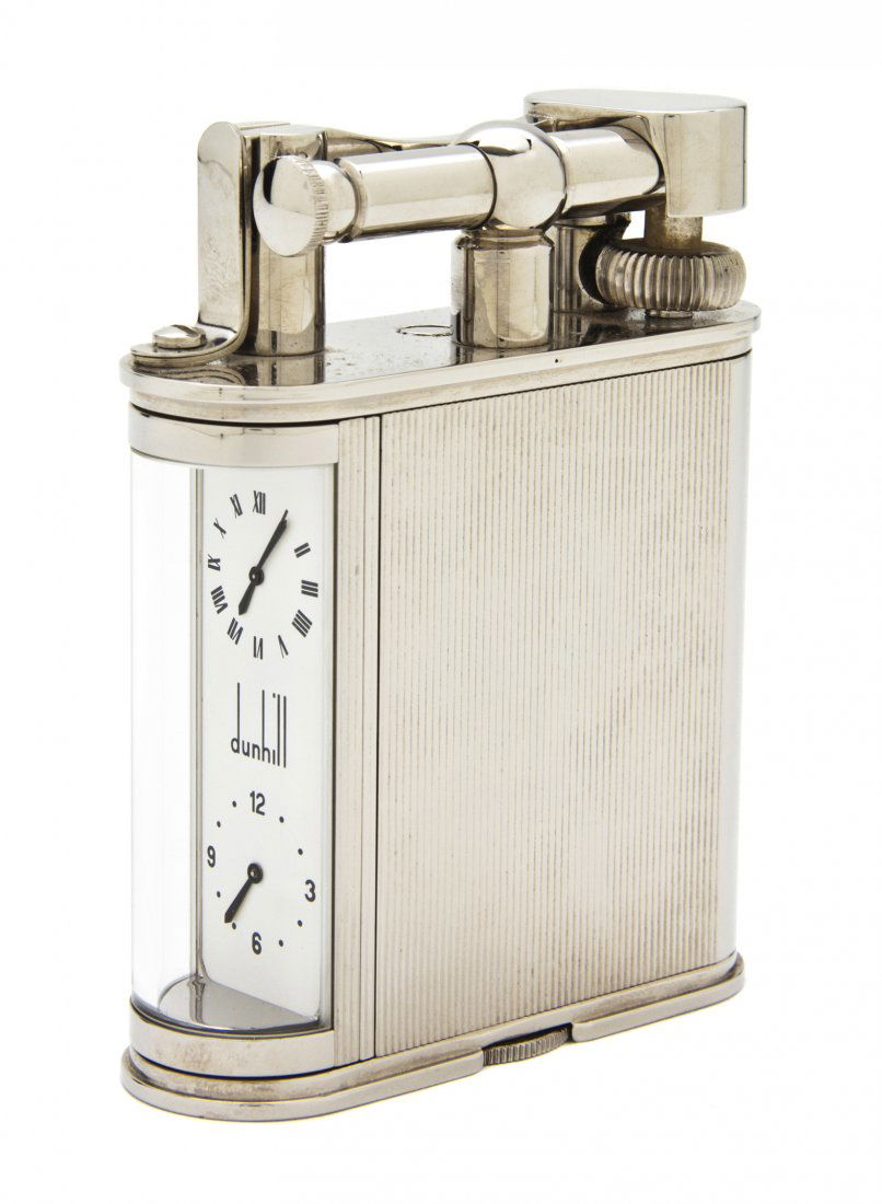 A Dunhill Watch Lighter, Height 4 inches.: A Dunhill Watch Lighter, having twin dials with Arabic and Roman numerals, contained in a fitted case. Height 4 inches.