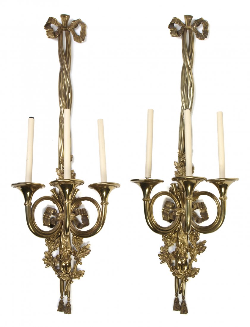 A Pair of Gilt Bronze Three-Light Sconces, Height : A Pair of Gilt Bronze Three-Light Sconces, each having a ribbon-tied backplate cast in a hunt motif with oak leaves, acorns and game, with candle arms in the form of horns. Height 44 1/8 inches.