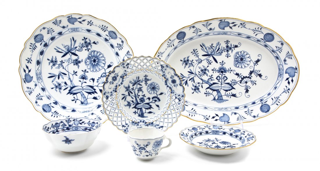 A Collection of Meissen Porcelain Table Service Ar: A Collection of Meissen Porcelain Table Service Articles, in the Blue Onion pattern, comprising 12 plates with a reticulated edge and gilt borders, 2 platters with gilt borders, a teacup, a serving bo
