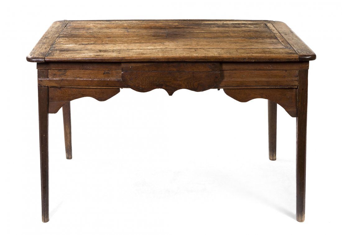 A Provincial Oak Writing Desk, Height 27 x width 4: A Provincial Oak Writing Desk, having a rectangular top with rounded corners over the shaped frieze set with a single drawer, raised on tapering legs. Height 27 x width 44 x depth 24 1/2 inches. Prope