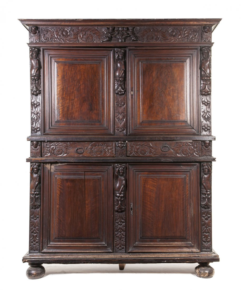 A Renaissance Revival Walnut Cupboard, Height 82 1: A Renaissance Revival Walnut Cupboard, having a molded cornice over a foliate and putti decorated frieze above two paneled doors over two drawers and two doors, raised on squat ball feet. Height 82 1/