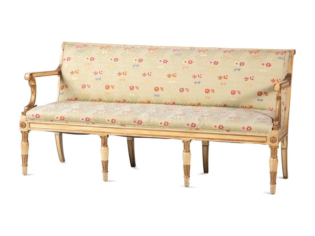 A Louis XVI Style Gold and Cream Paint Decorated Upholstered Settee: A Louis XVI Style Gold and Cream Paint Decorated Upholstered Settee 19th Century with carved dolphin arm supports. Height 35 1/2 x width 68 x depth 23 inches.