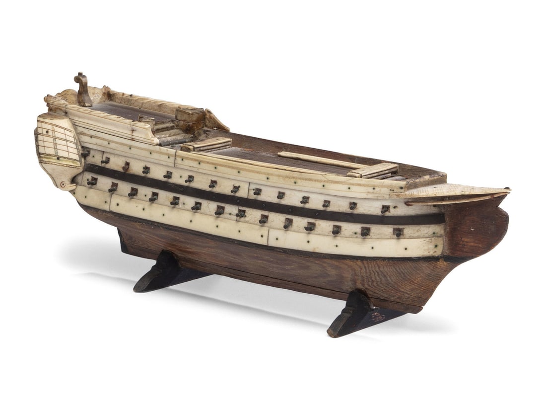 A French Prisoner of War Fruitwood and Bone Model Gunship: A French Prisoner of War Fruitwood and Bone Model Gunship Early 19th Century cover on boat deck opens to reveal twenty-five bone dominoes. Height 4 1/2 x width 13 1/4 x depth 3 1/2 inches.