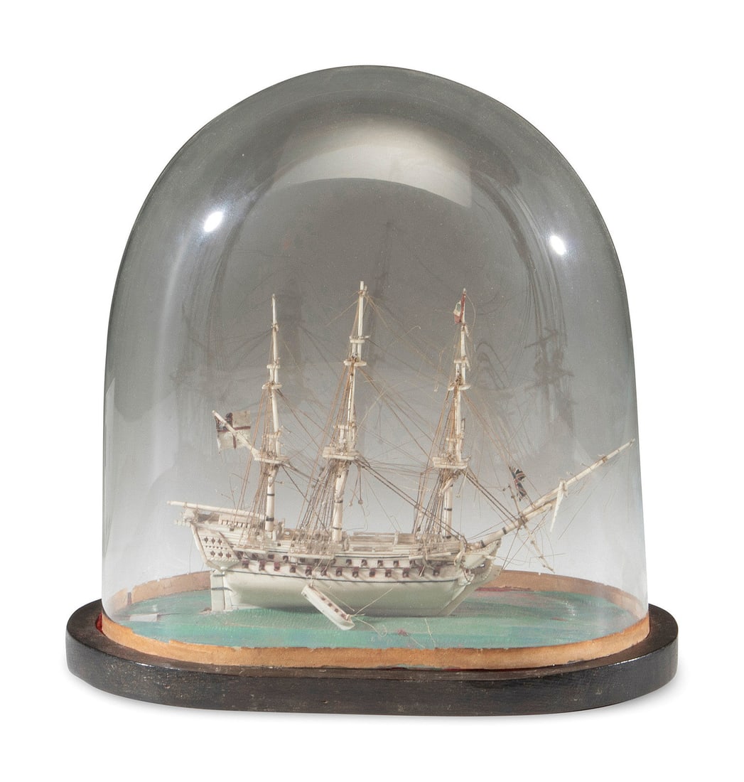 A French Prisoner of War Bone Model of a British Warship: A French Prisoner of War Bone Model of a British Warship Early 19th Century on a wood platform under a glass dome. Ship model height 6 1/4 x length 8 1/4 inches; height overall 11 x width of platform